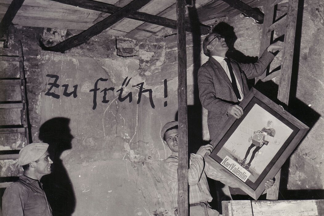 Hannes König beim Bau des Musäums, steht auf Leiter mit Valentin bild in der Hand